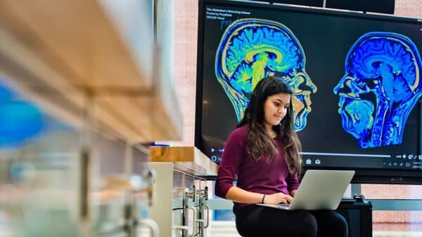 Synapto brain research display and student at the A. James Clark Hall Open House.