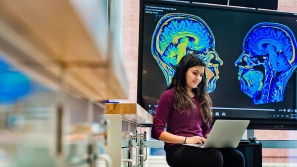 Synapto brain research display and student at the A. James Clark Hall Open House.