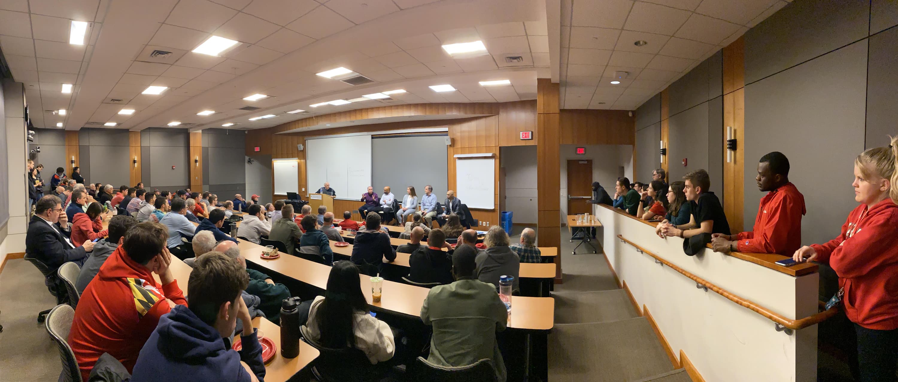 Students fill classroom with panel speaking in the front of the room