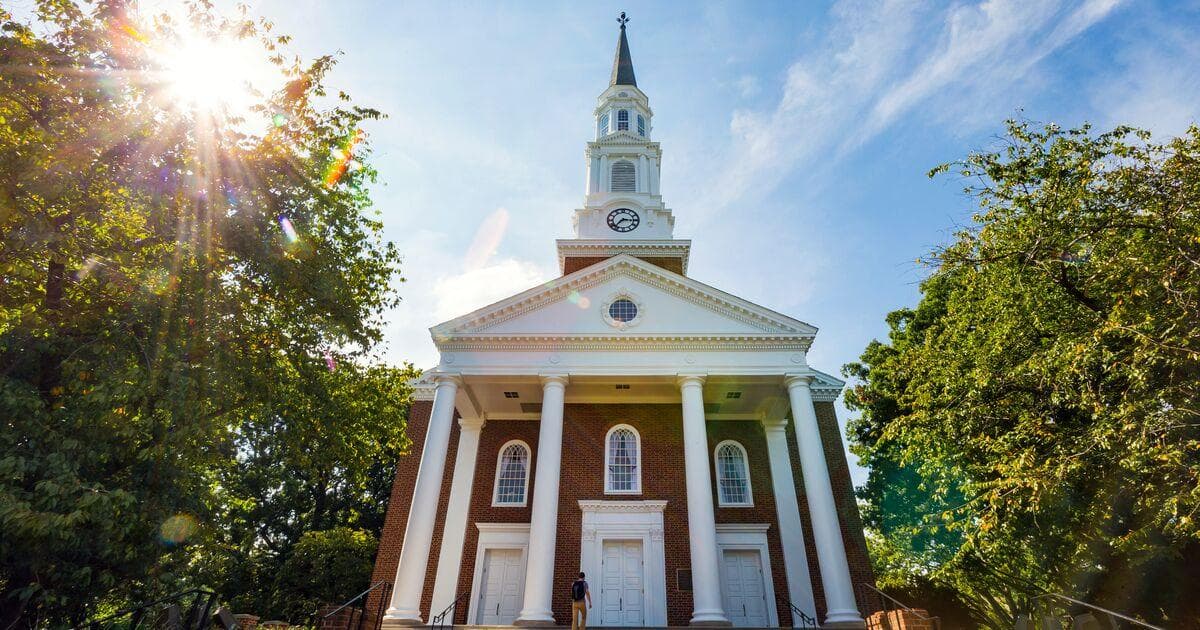 White columns and steeple of the Memorial Chapel with green trees on either side