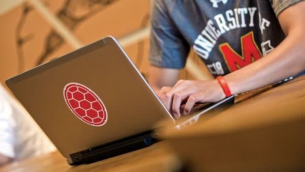 A picture of a male student using his laptop on a table