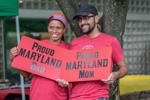 Two people holding signs that say Proud Maryland Parents