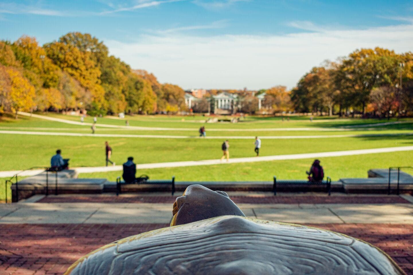 Students walking across McKeldin Mall with the Testudo statue in the Foreground
