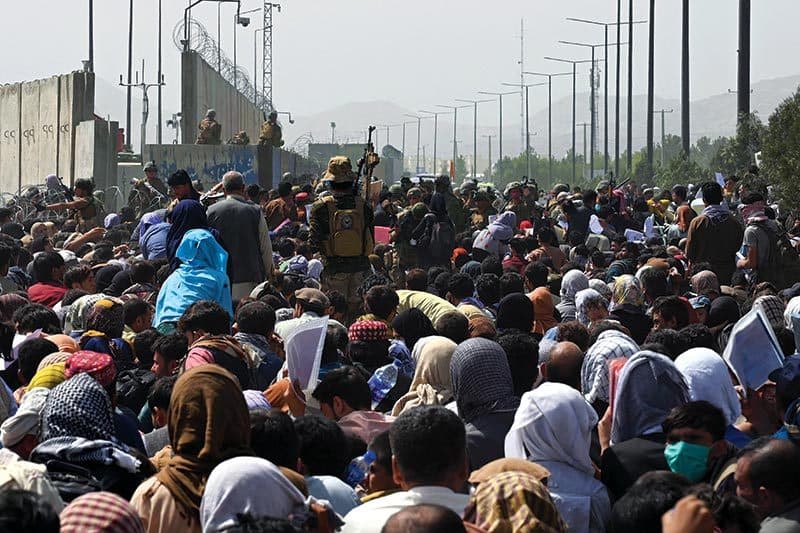 evacuees wait ﻿outside Kabul International Airport