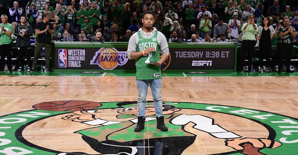 Rehan Staton holds award on Celtics home court