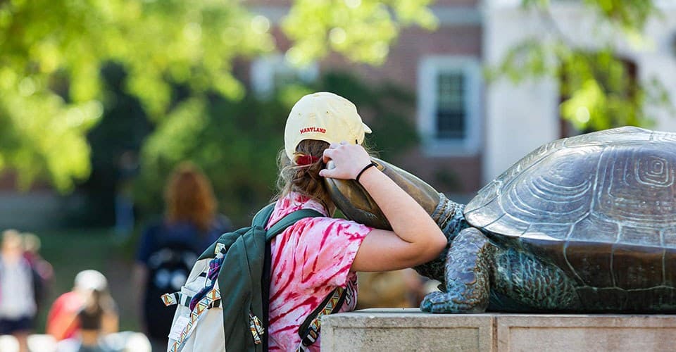 Student hugs Testudo statue