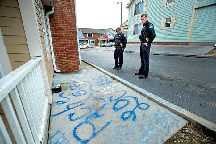 police officers look at writing on sidewalk