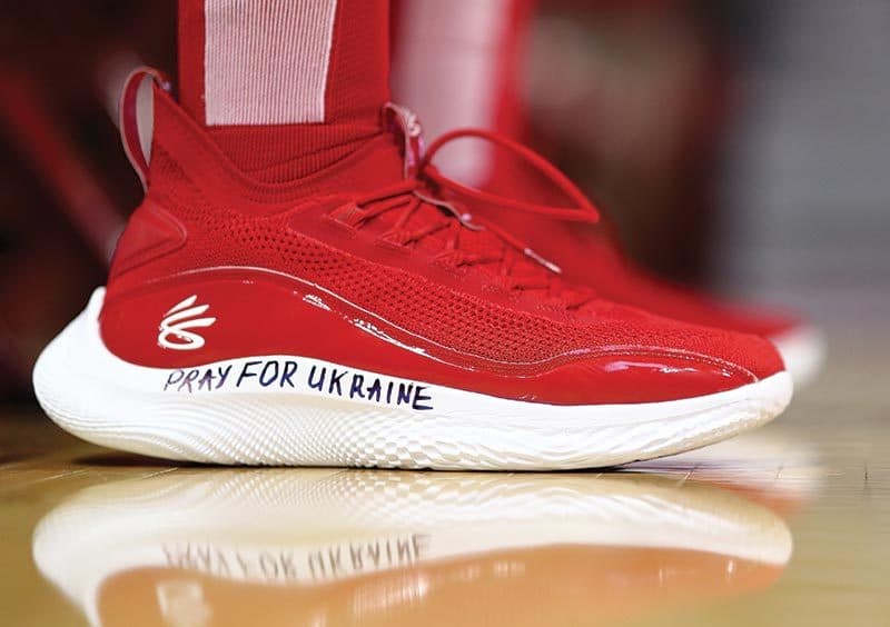 Red basketball shoes that say "PRAY FOR UKRAINE" in marker