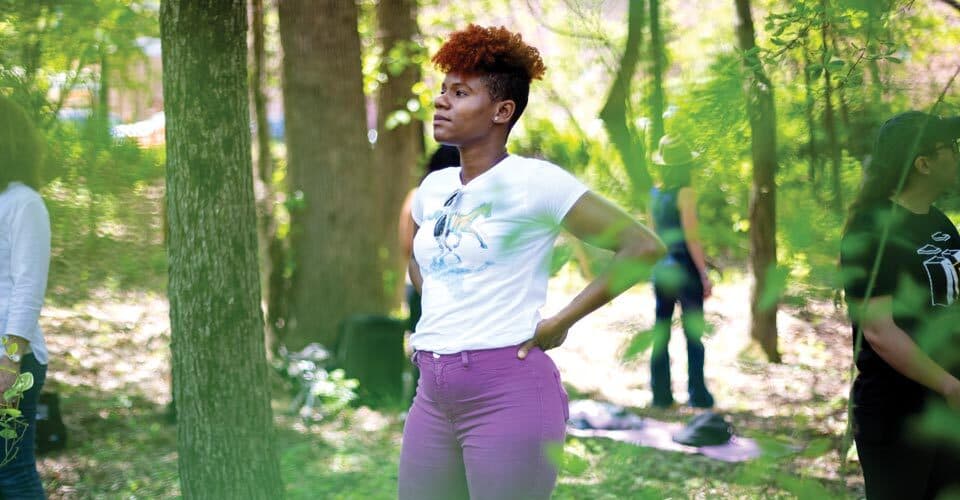Keisha Prawl-Woods stands in the forest