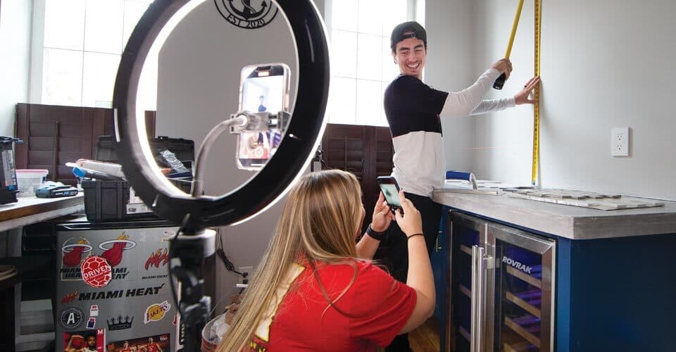 Kylie D’Alessio films Alex measuring wall