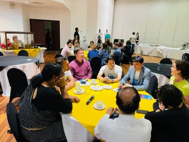 Group of conference participants sitting talking at a round table