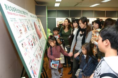 Women and children looking at an exhibition panel on the United Nations Convention on the Rights of the Child