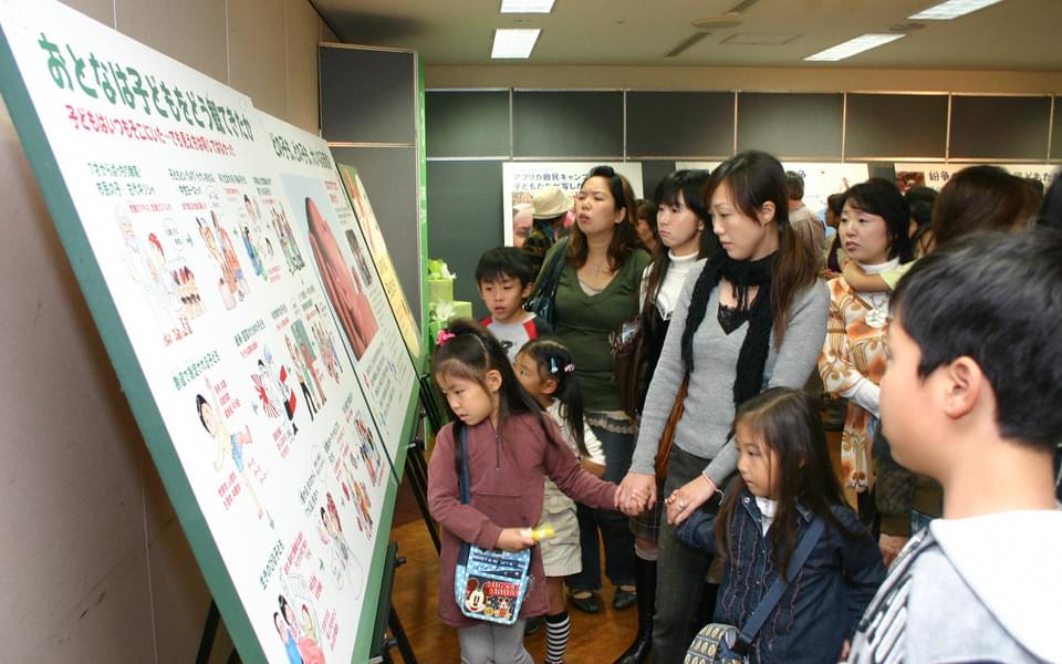 Women and children looking at an exhibition panel on the United Nations Convention on the Rights of the Child