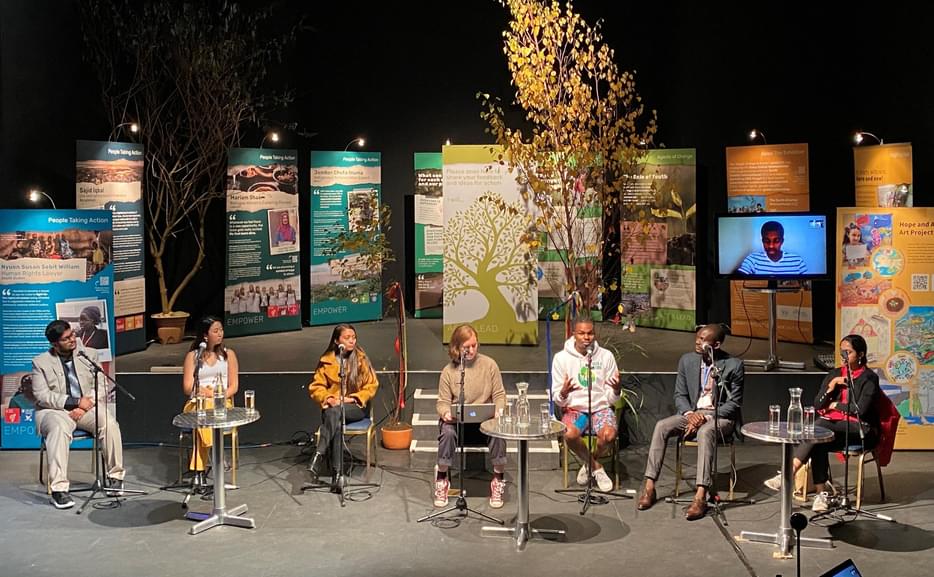 seven youth panelists sitting infant of exhibition panels