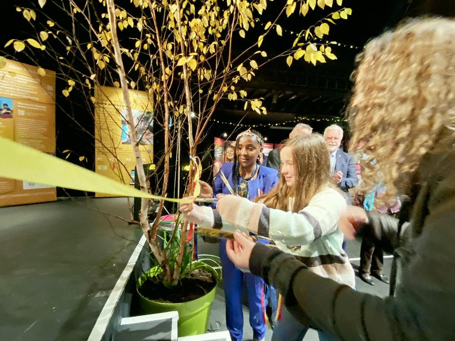 Three people cutting ribbon to open exhibition