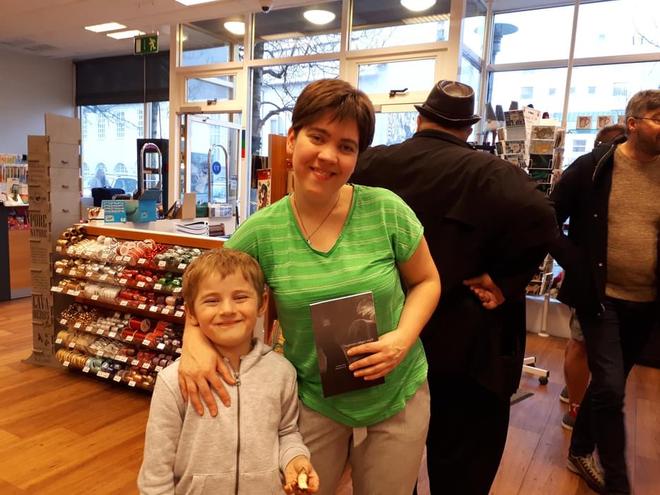 Eyrun posing with her son with her book