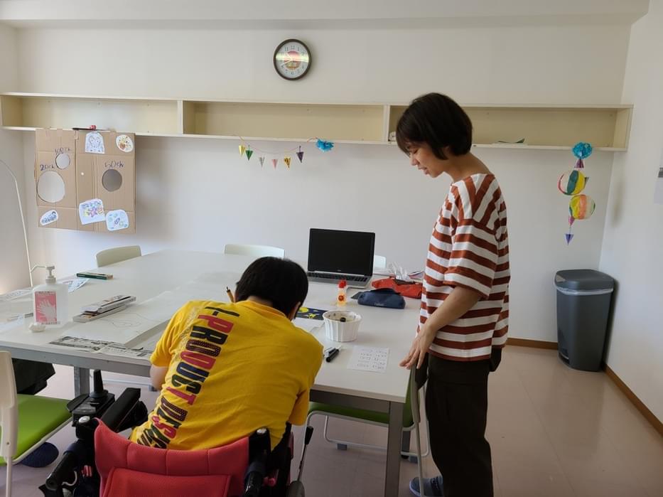 Hanae talking with a person with disabilities