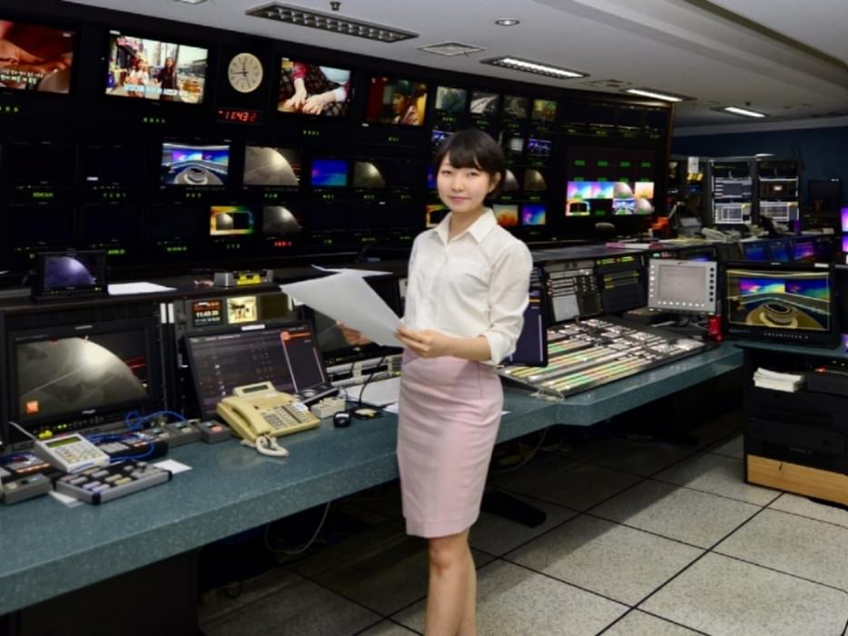 Jiye at work standing in a news studio
