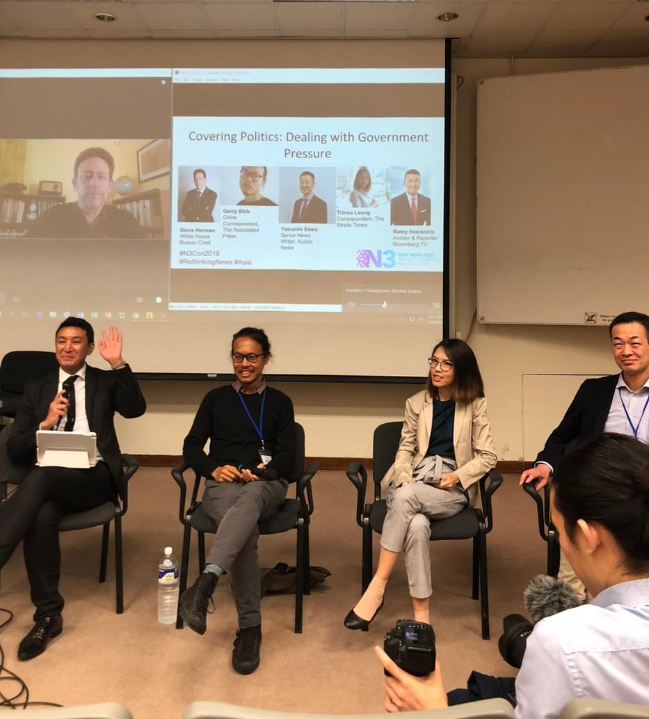 Trinna with other panelists at a workshop in front of a projected screen with their faces pictured