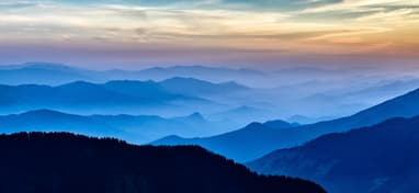 A panoramic picture of layers of mountains in the setting sun