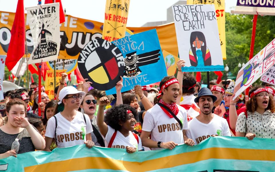 diverse group of youth climate activist march with banners
