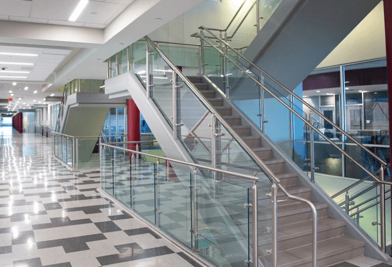 Modern steel and glass railing design for stairs and balcony in a school interior.