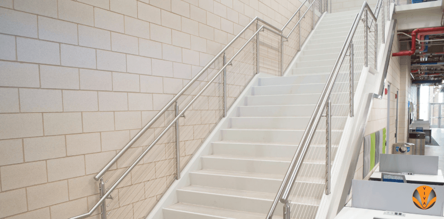 Clean white staircase with sleek stainless steel handrails and cable infill.