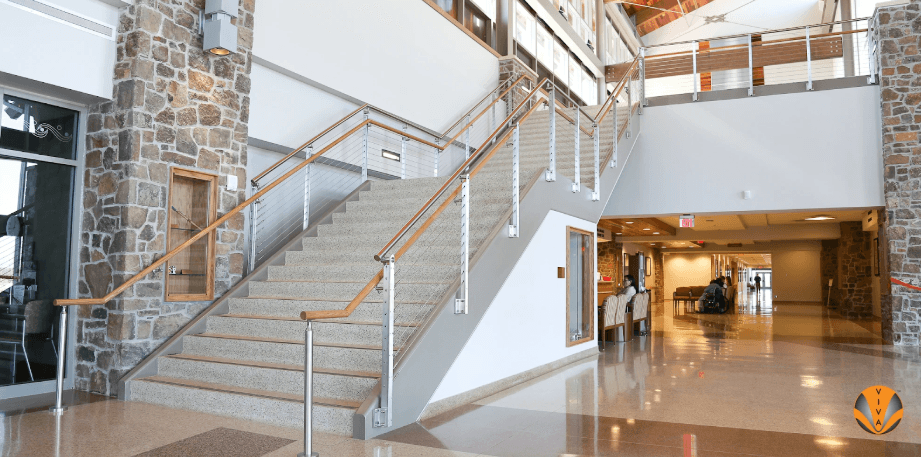 Inviting interior staircase featuring wood handrails and stone accents in a bright lobby.
