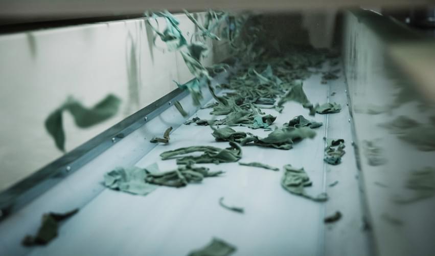 Textile waste from post-consumer or post-industrial origin entering the Recover™ process, to be cut and then shredded into new recycled cotton fibers, ready to be blended with a carrier fiber.