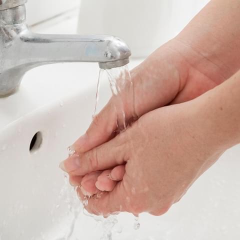 Person washing hands under running water