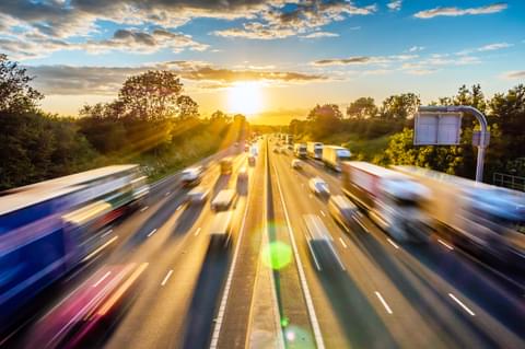 Heavy traffic moving at speed on UK motorway in England at sunset
