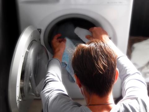 The young man washes clothes in the washing machin 2022 11 16 21 05 41 utc