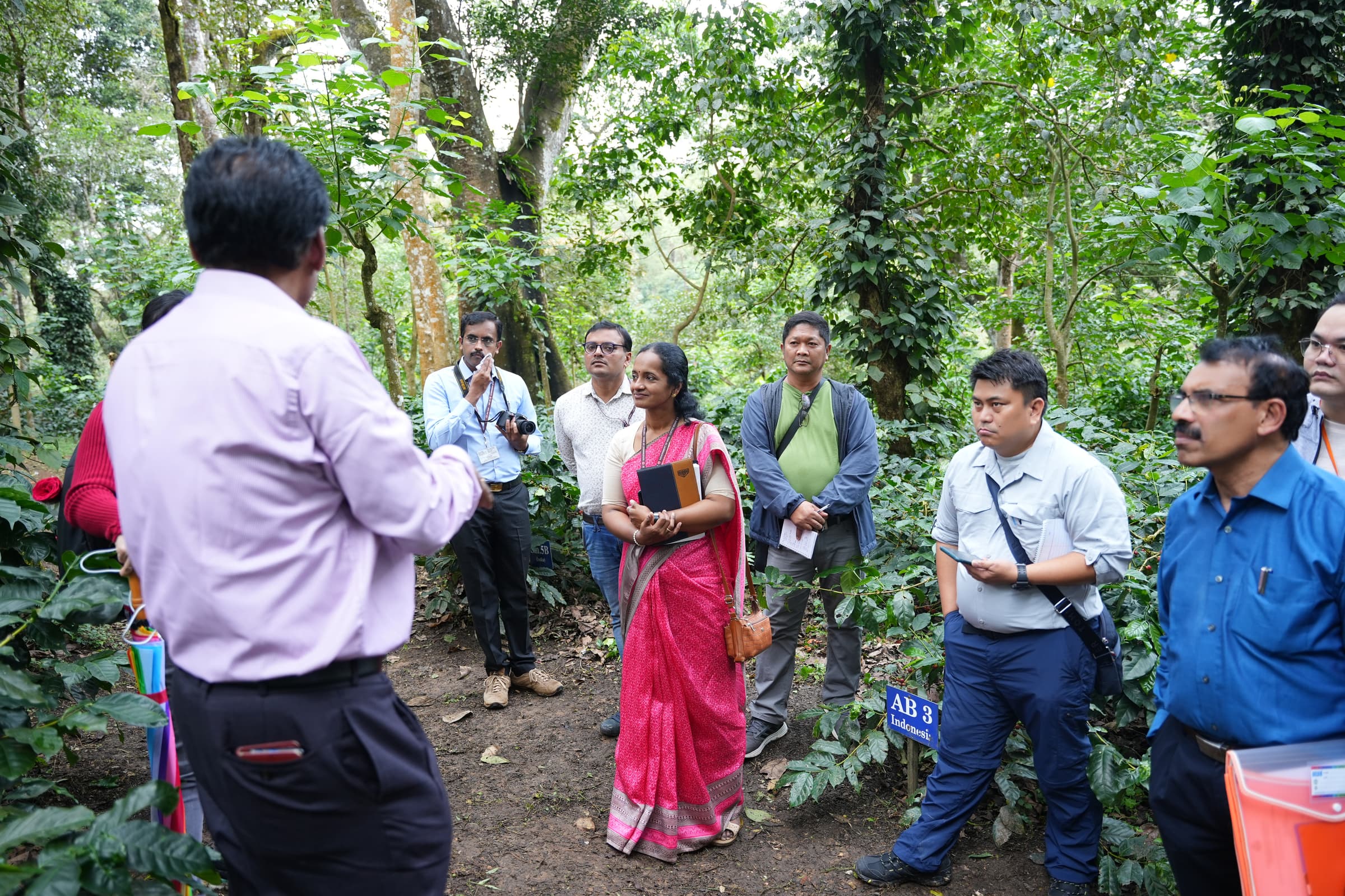 With his back to the camera, Dr. Surya Prakash, Director of Research at CCRI, explains to staff and Filipino visitors about the layout and the design of the IMLVT field trial at Balehonnur.